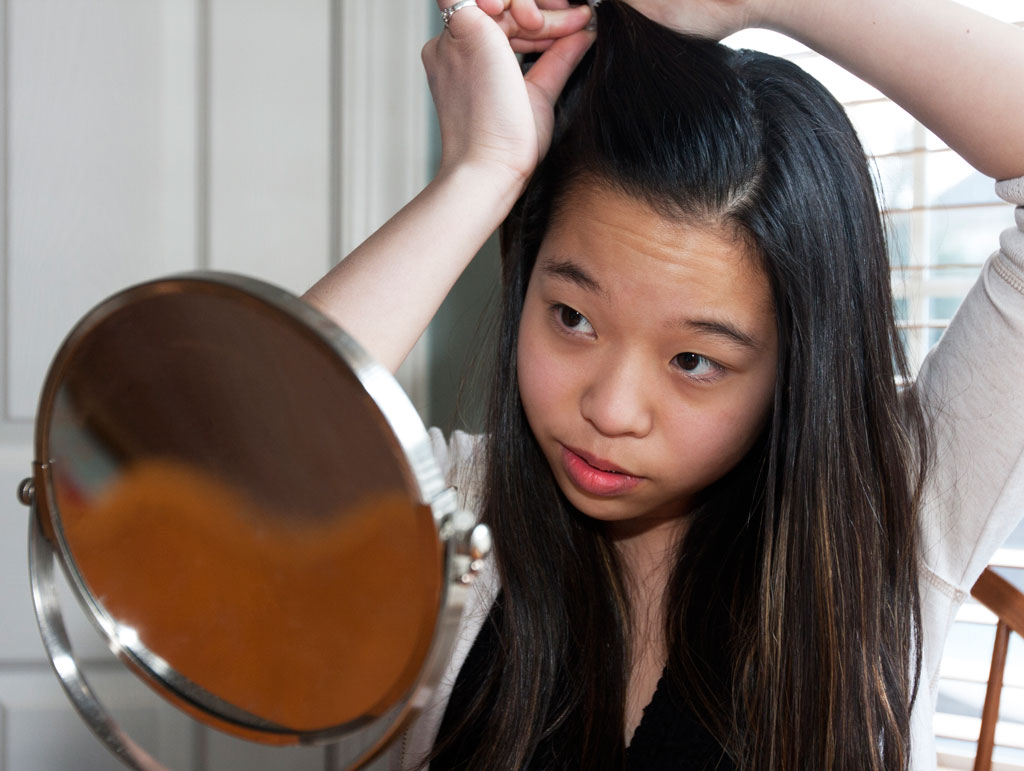 girl looking into mirror